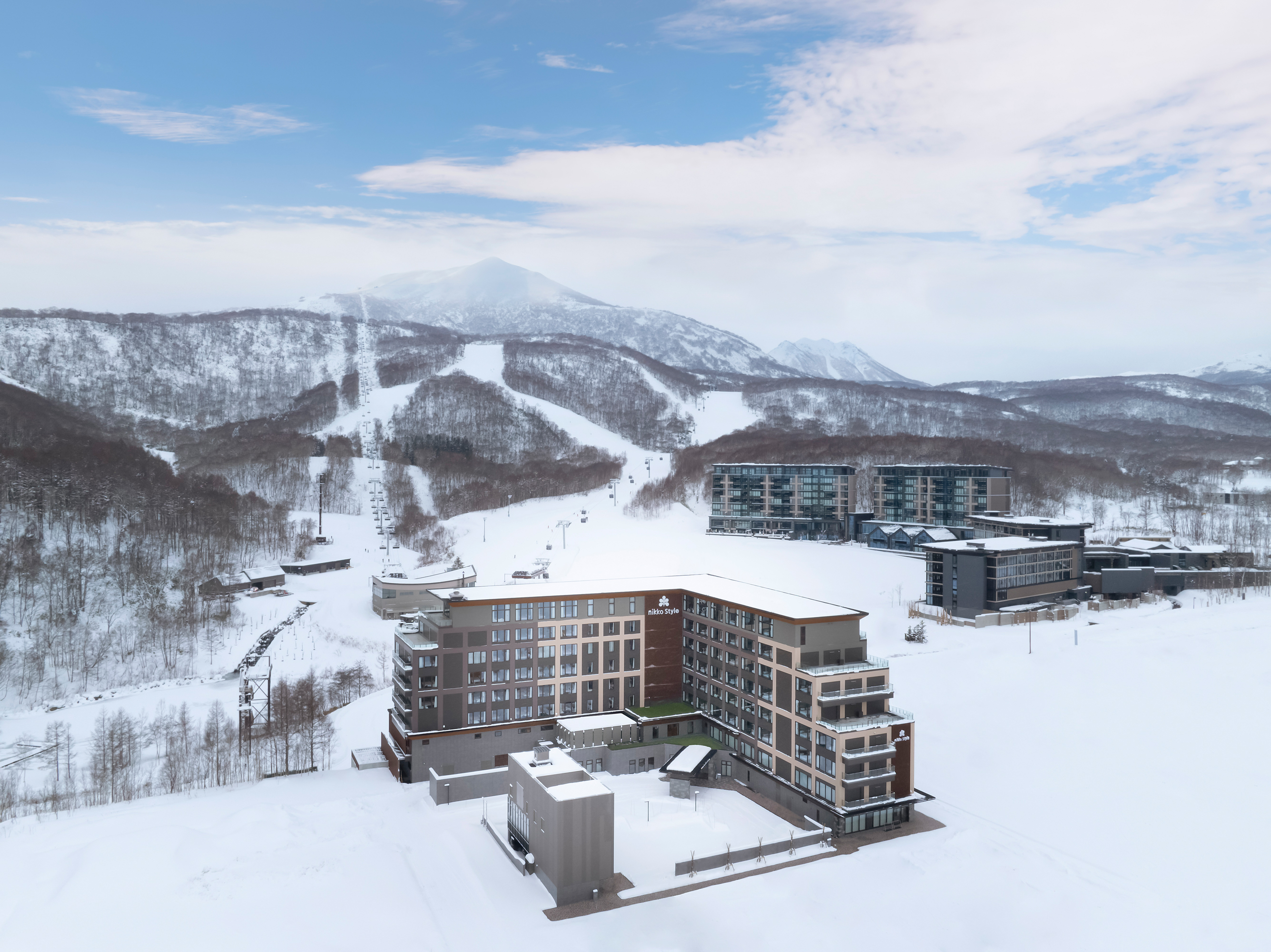 The exterior of an L shaped hotel amid a snowy back drop